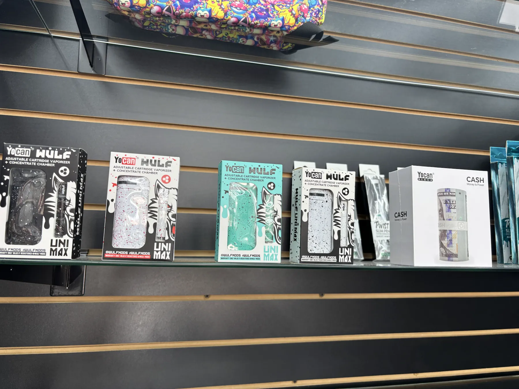 Boxed vape devices displayed on a shelf inside Imperial Beach Smoke and Market